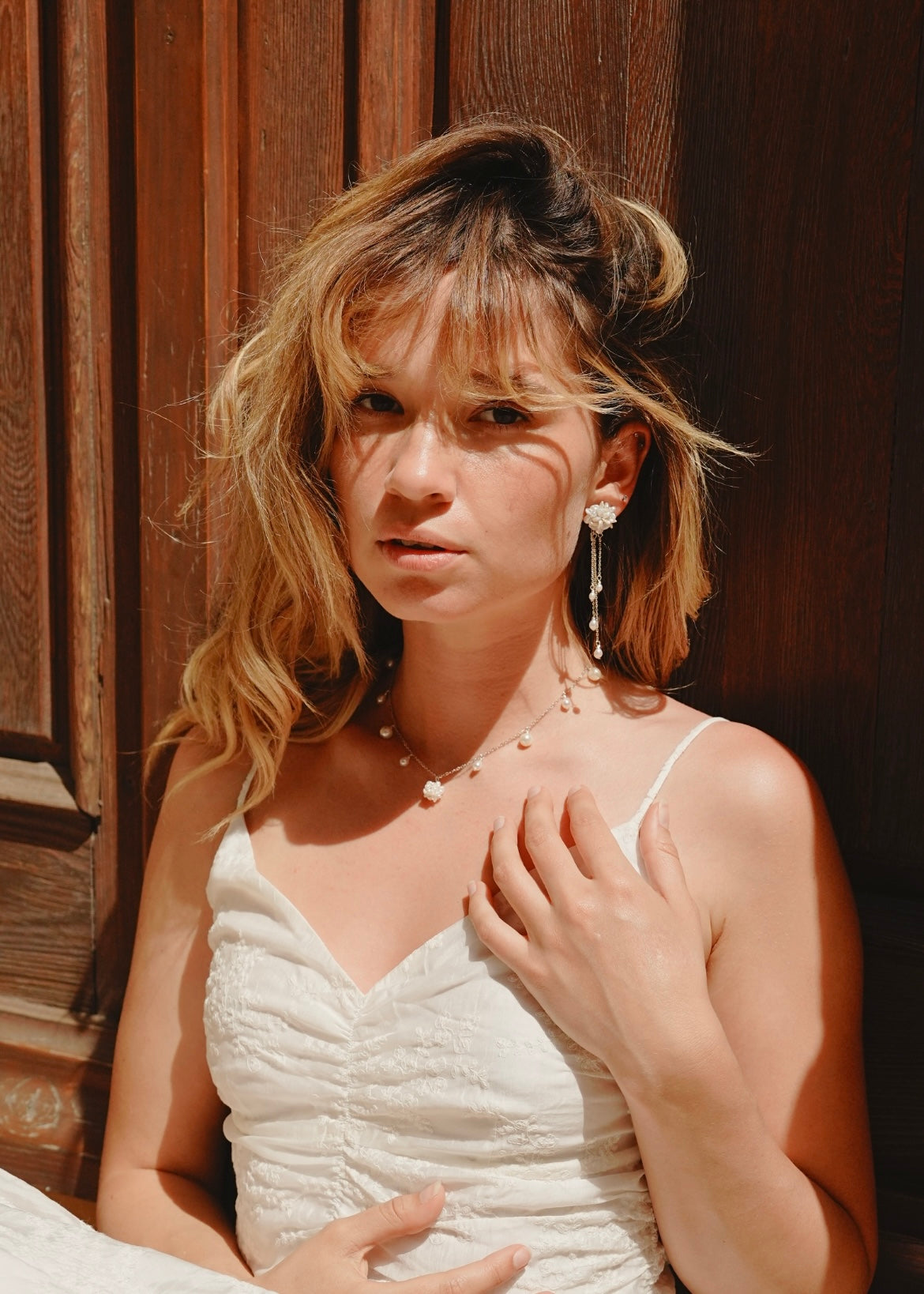 Woman in a white dress with a wooden background