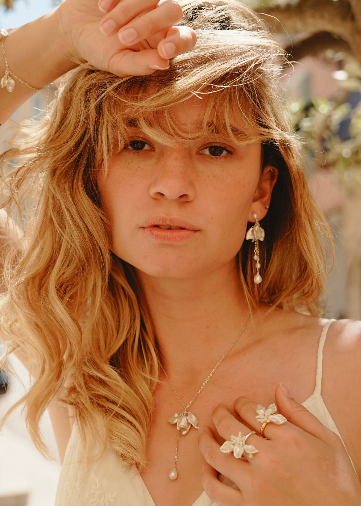 Woman with blonde hair and jewelry outdoors