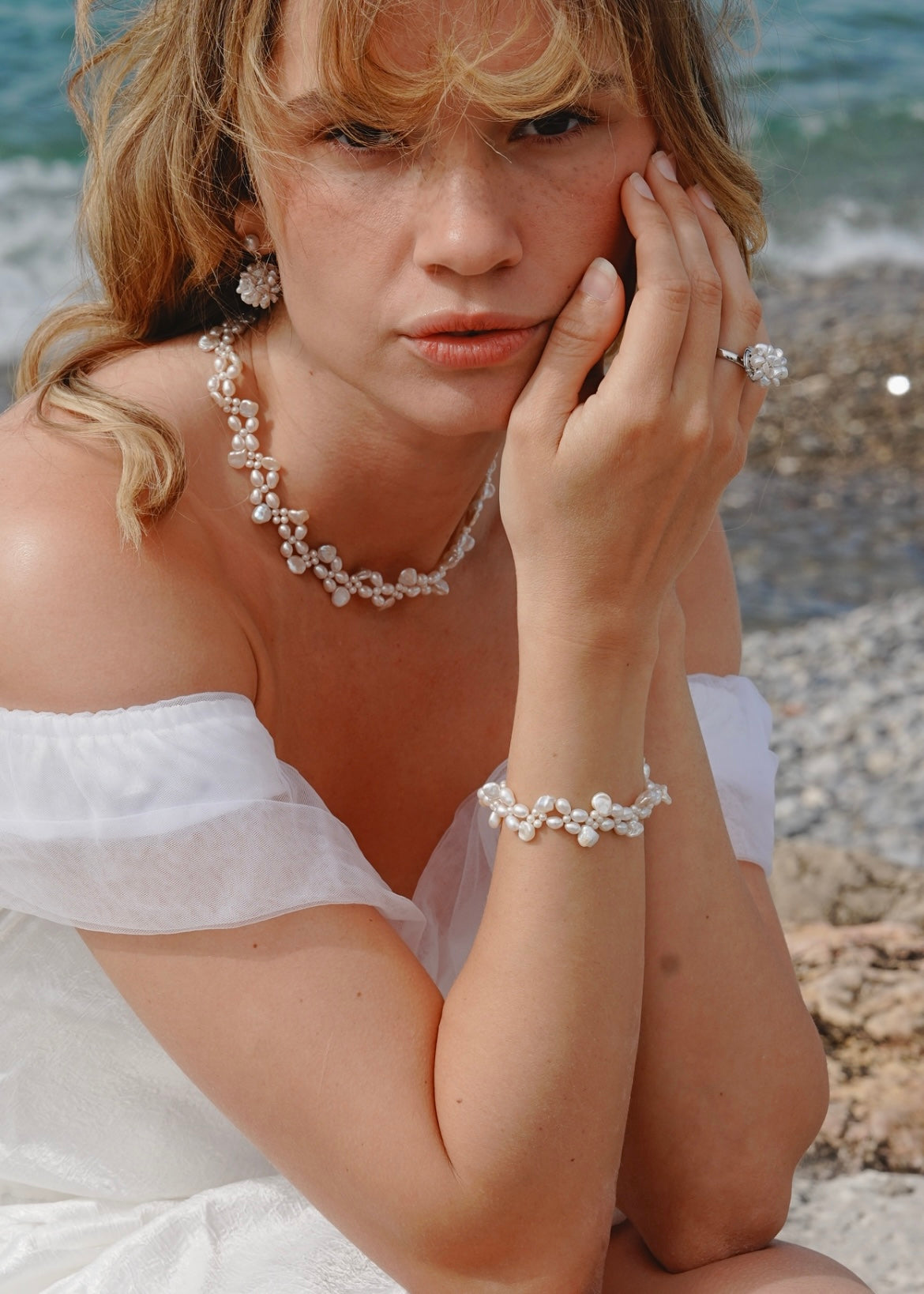 Woman wearing pearl jewelry on a beach