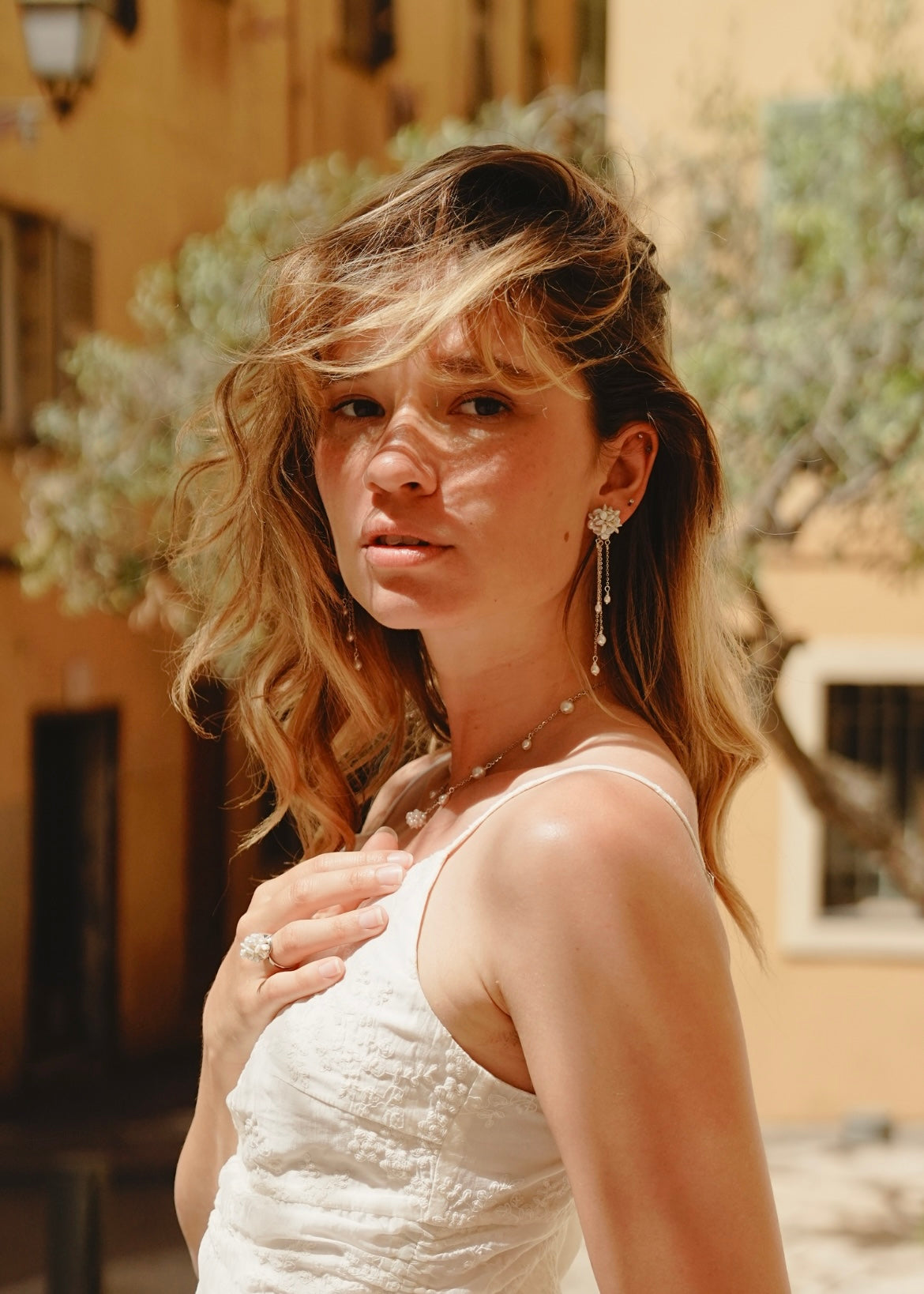 Woman in a white dress with jewelry outdoors