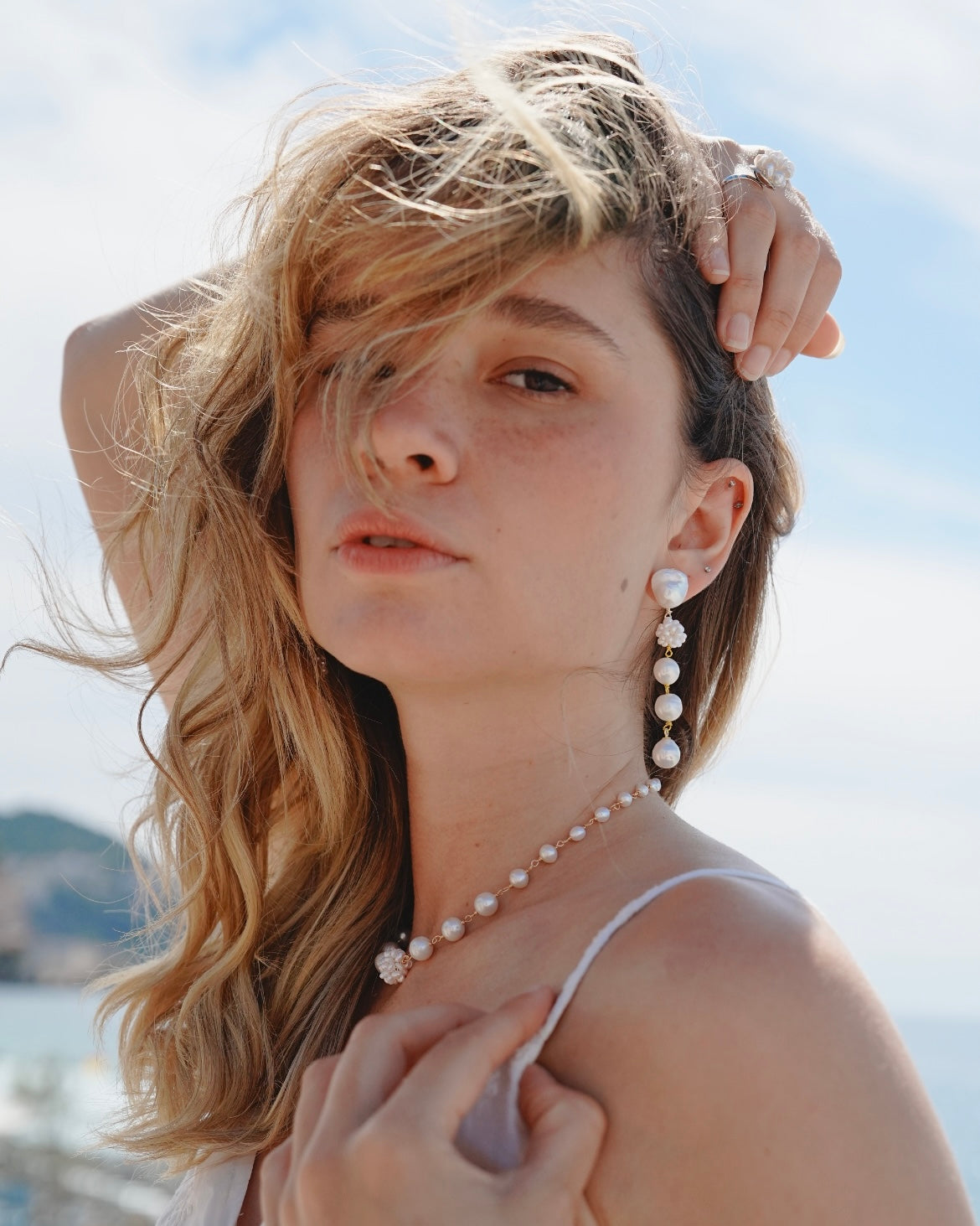 Woman wearing a pearl necklace and earrings with a blurred background