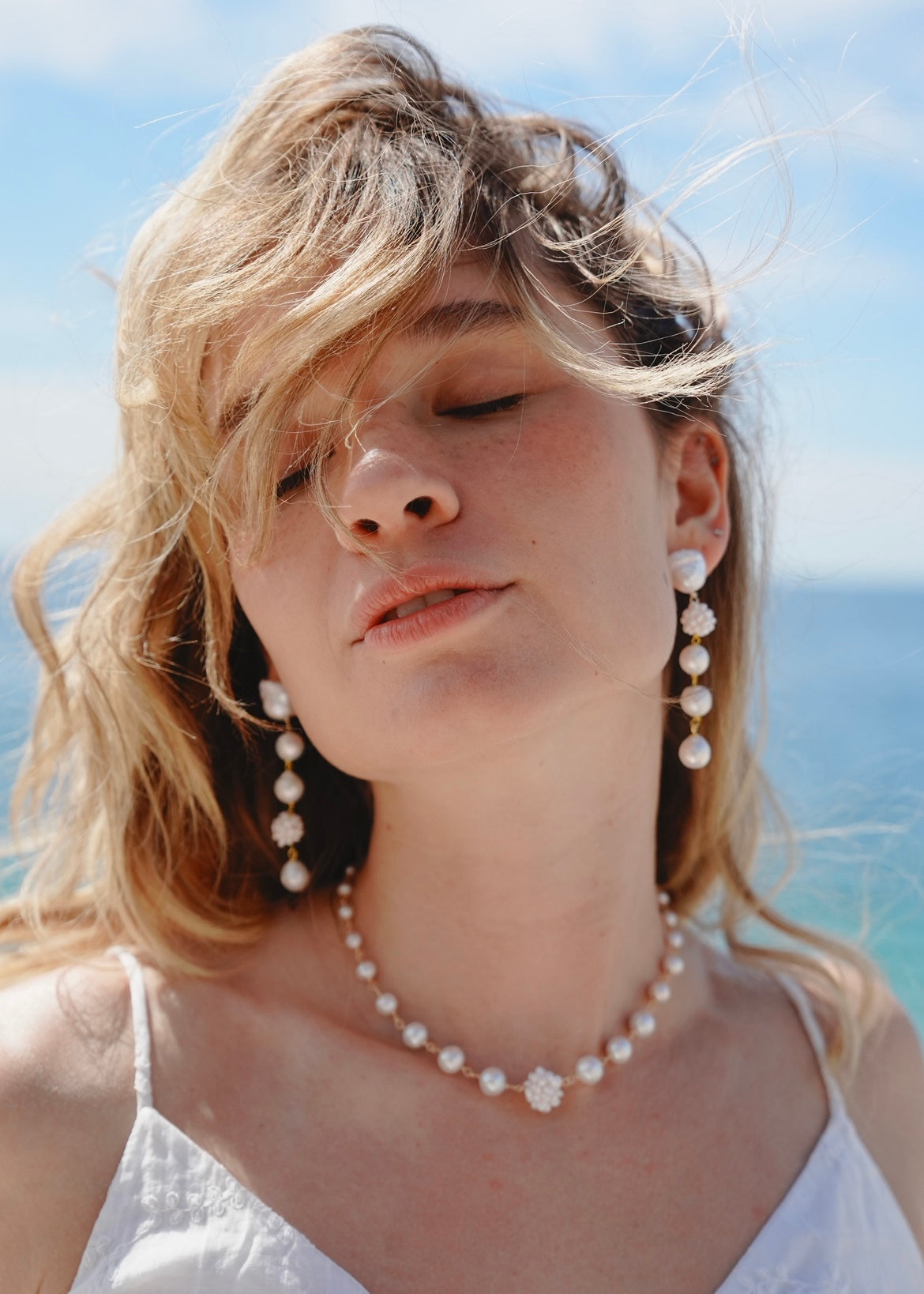 Woman wearing pearl jewelry with a blurred background